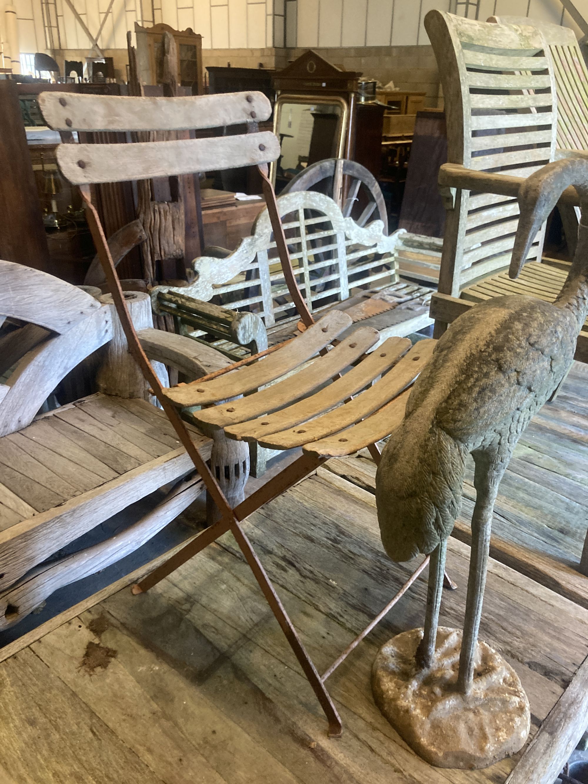 A folding metal slatted garden chair, together with a cast metal garden flamingo ornament, height 77cm